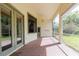 Relaxing screened-in patio with brick flooring, ceiling fan, and views of the surrounding greenery at 1852 Longview Ln, Tarpon Springs, FL 34689
