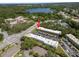 Community aerial view shows buildings, parking areas, and nearby lake at 2003 Greenbriar Blvd # 1, Clearwater, FL 33763