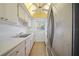 Narrow galley kitchen with stainless steel refrigerator and white tile backsplash at 2003 Greenbriar Blvd # 1, Clearwater, FL 33763