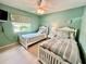 Bright bedroom featuring two twin beds, neutral carpet, and fresh green paint at 2131 Ridge S Rd # 76, Largo, FL 33778