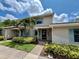 Home exterior featuring manicured landscaping, a covered front entry, and light blue shutters at 2131 Ridge S Rd # 76, Largo, FL 33778