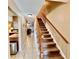 Hallway featuring neutral walls, tile floors, a wooden staircase, and access to multiple rooms at 2131 Ridge S Rd # 76, Largo, FL 33778