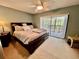 Cozy main bedroom featuring a ceiling fan, large windows, and comfortable furnishings at 2131 Ridge S Rd # 76, Largo, FL 33778