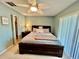 Bright main bedroom featuring a ceiling fan, natural light, and comfortable queen bed at 2131 Ridge S Rd # 76, Largo, FL 33778