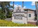 Coastal Ridge community sign with well-maintained landscaping, indicating a deed restricted neighborhood at 2131 Ridge S Rd # 76, Largo, FL 33778