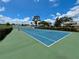 Community tennis court surrounded by trees and blue skies at 2131 Ridge S Rd # 76, Largo, FL 33778