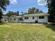 Spacious backyard with lush green grass, trees, and white home at 22365 Panorama St, Brooksville, FL 34601