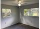 Bright bedroom featuring two windows, neutral walls, and ceiling fan at 22365 Panorama St, Brooksville, FL 34601