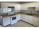 Well-lit kitchen featuring white cabinets, appliances, and a window at 22365 Panorama St, Brooksville, FL 34601