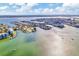 Aerial view of waterfront homes and canals with boats sailing on the open water at 234 Palm Sw Is, Clearwater Beach, FL 33767