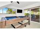 Bright game room features a billiard table, flat screen TV, and sliding glass doors to the outdoor grill at 234 Palm Sw Is, Clearwater Beach, FL 33767