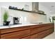 A modern kitchen featuring a long counter with wooden drawers and a stainless steel range hood at 234 Palm Sw Is, Clearwater Beach, FL 33767
