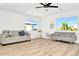 Spacious living room with two sofas, light wood floors, and plenty of natural light from the large windows at 234 Palm Sw Is, Clearwater Beach, FL 33767