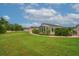 View of the backyard showcasing a lush lawn and enclosed porch at 241 Royal Palm Way, Spring Hill, FL 34608