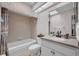 Bathroom with a combined bathtub and shower, white vanity, and neutral tile at 241 Royal Palm Way, Spring Hill, FL 34608