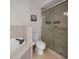 Bright bathroom features a tiled shower, soaking tub, and toilet at 241 Royal Palm Way, Spring Hill, FL 34608