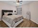 Bedroom with a large bed, hardwood floors, a ceiling fan, and shuttered windows at 241 Royal Palm Way, Spring Hill, FL 34608