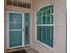 Inviting front entrance with a blue door and decorative glass, complemented by a stylish window and modern doorbell at 241 Royal Palm Way, Spring Hill, FL 34608