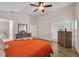Main bedroom boasts wood floors, a ceiling fan, a dresser and an ensuite bathroom at 241 Royal Palm Way, Spring Hill, FL 34608