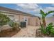 Enclosed patio with brick pavers, AC unit, tropical landscaping, and backdoor access to the house at 241 Royal Palm Way, Spring Hill, FL 34608