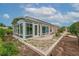 Exterior view of a home featuring a sunroom addition with large windows and landscaped yard at 241 Royal Palm Way, Spring Hill, FL 34608