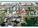 Aerial view of a neighborhood with waterfront properties, showcasing lush landscaping, docks, and canal access at 2801 Gulf Blvd, Belleair Beach, FL 33786