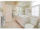 Bright bathroom boasts a white vanity, toilet, and shower with a glass door and tile flooring at 2801 Gulf Blvd, Belleair Beach, FL 33786