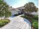 Circular driveway leading to a well-maintained home with lush landscaping and mature palm trees at 2801 Gulf Blvd, Belleair Beach, FL 33786