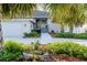 Charming home featuring a colorful front door, a well-manicured lawn, and mature palm trees at 2801 Gulf Blvd, Belleair Beach, FL 33786