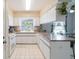 Bright kitchen features white cabinets, tile flooring, and a window over the sink for natural light at 2801 Gulf Blvd, Belleair Beach, FL 33786