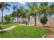 Landscaped backyard featuring a grass lawn, brick border, hammock, and fire pit with seating at 30317 Rattana Ct, Wesley Chapel, FL 33545