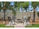 Backyard patio featuring a brick fire pit with outdoor seating, surrounded by palm trees and manicured landscaping at 30317 Rattana Ct, Wesley Chapel, FL 33545