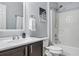 Bright bathroom featuring a dark wood vanity, white countertop, framed mirror and shower with tub at 30317 Rattana Ct, Wesley Chapel, FL 33545