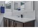 Bathroom vanity with dark wood cabinets, white countertop, a large mirror and subway tile backsplash at 30317 Rattana Ct, Wesley Chapel, FL 33545