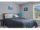 Bedroom with a queen bed with gray bedding, two paintings and natural light at 30317 Rattana Ct, Wesley Chapel, FL 33545