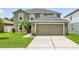 Beautiful two-story home with a well-manicured lawn, large garage, and attractive landscaping at 30317 Rattana Ct, Wesley Chapel, FL 33545