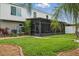 Home exterior with a screened patio, manicured lawn, and landscaping at 30317 Rattana Ct, Wesley Chapel, FL 33545