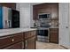Modern kitchen featuring stainless steel appliances, stylish backsplash, and granite countertops at 30317 Rattana Ct, Wesley Chapel, FL 33545