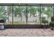 Screened patio with brick floor and view of the backyard featuring a fire pit and hammock at 30317 Rattana Ct, Wesley Chapel, FL 33545