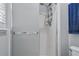 Bathroom shower with a frosted glass door, shower head and blue hand towel at 30317 Rattana Ct, Wesley Chapel, FL 33545