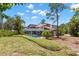 Expansive backyard featuring a screened-in pool, lush landscaping, and serene surroundings at 3133 Harvest Moon Dr, Palm Harbor, FL 34683
