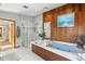 Unique bathroom with a modern tub, separate shower and stylish wood paneling at 3133 Harvest Moon Dr, Palm Harbor, FL 34683