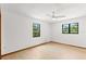 Simple bedroom with wood floors, white walls, ceiling fan and natural light coming through the windows at 3133 Harvest Moon Dr, Palm Harbor, FL 34683