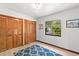 Bright bedroom featuring wood closet doors, a window, and a blue patterned rug at 3133 Harvest Moon Dr, Palm Harbor, FL 34683