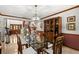 Formal dining room with a glass-top table, wooden chairs, and a built-in display cabinet at 3133 Harvest Moon Dr, Palm Harbor, FL 34683
