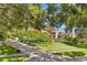 Landscaped yard with mature trees leading to a well-maintained two-story home in a desirable neighborhood at 3133 Harvest Moon Dr, Palm Harbor, FL 34683