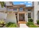 Inviting front entrance features a unique architectural design, tiled entryway, and beautifully landscaped surroundings at 3133 Harvest Moon Dr, Palm Harbor, FL 34683