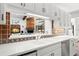 Modern kitchen with white cabinets and a sink overlooking a spacious living area at 3133 Harvest Moon Dr, Palm Harbor, FL 34683