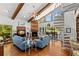 Inviting living room with a fireplace, spiral staircase, beamed ceilings, and patio access at 3133 Harvest Moon Dr, Palm Harbor, FL 34683