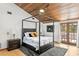 Inviting main bedroom with modern furnishings, wood ceiling, and a sliding glass door leading to the outside at 3133 Harvest Moon Dr, Palm Harbor, FL 34683